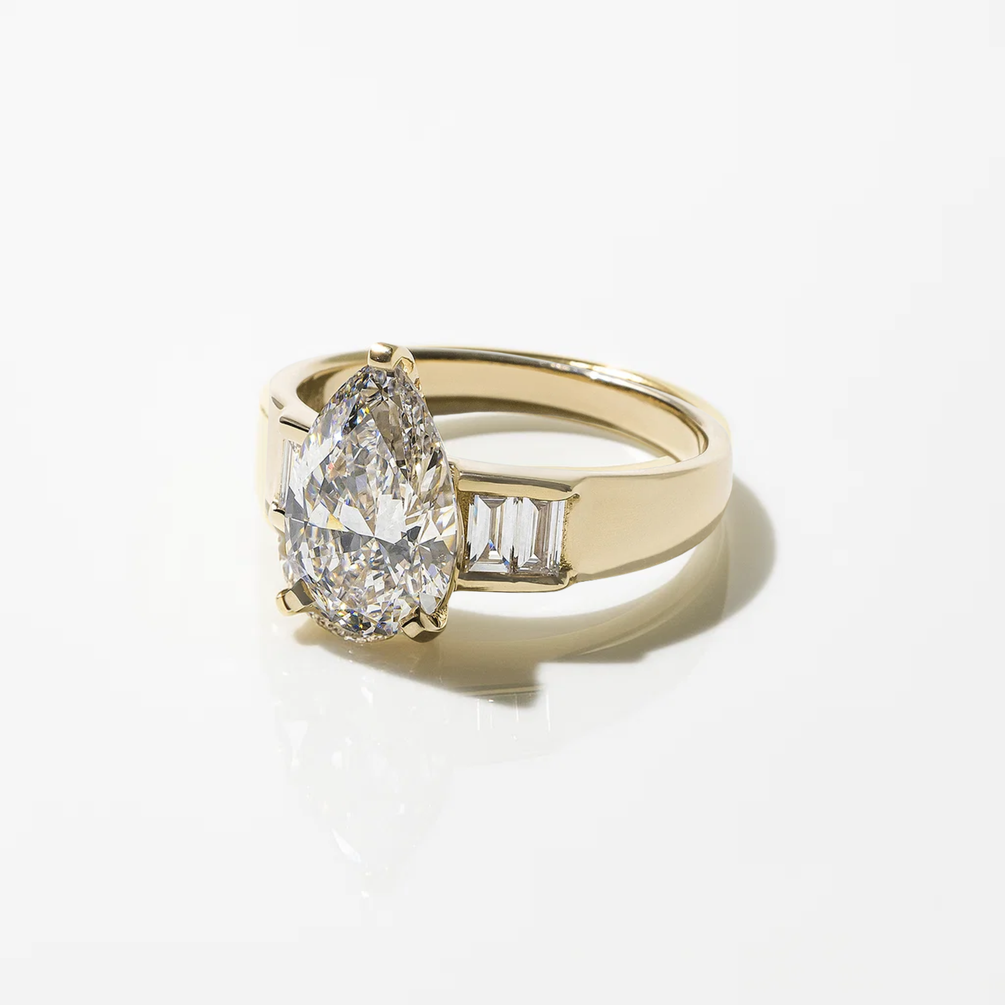 Gold ring with a pear-shaped diamond and baguette side stones