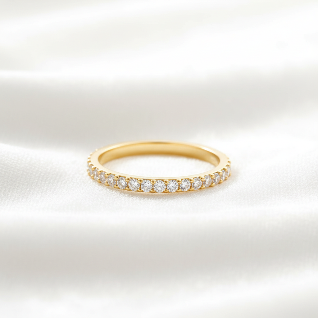14K gold full eternity wedding band for women on wavy white velvet, studio lighting
