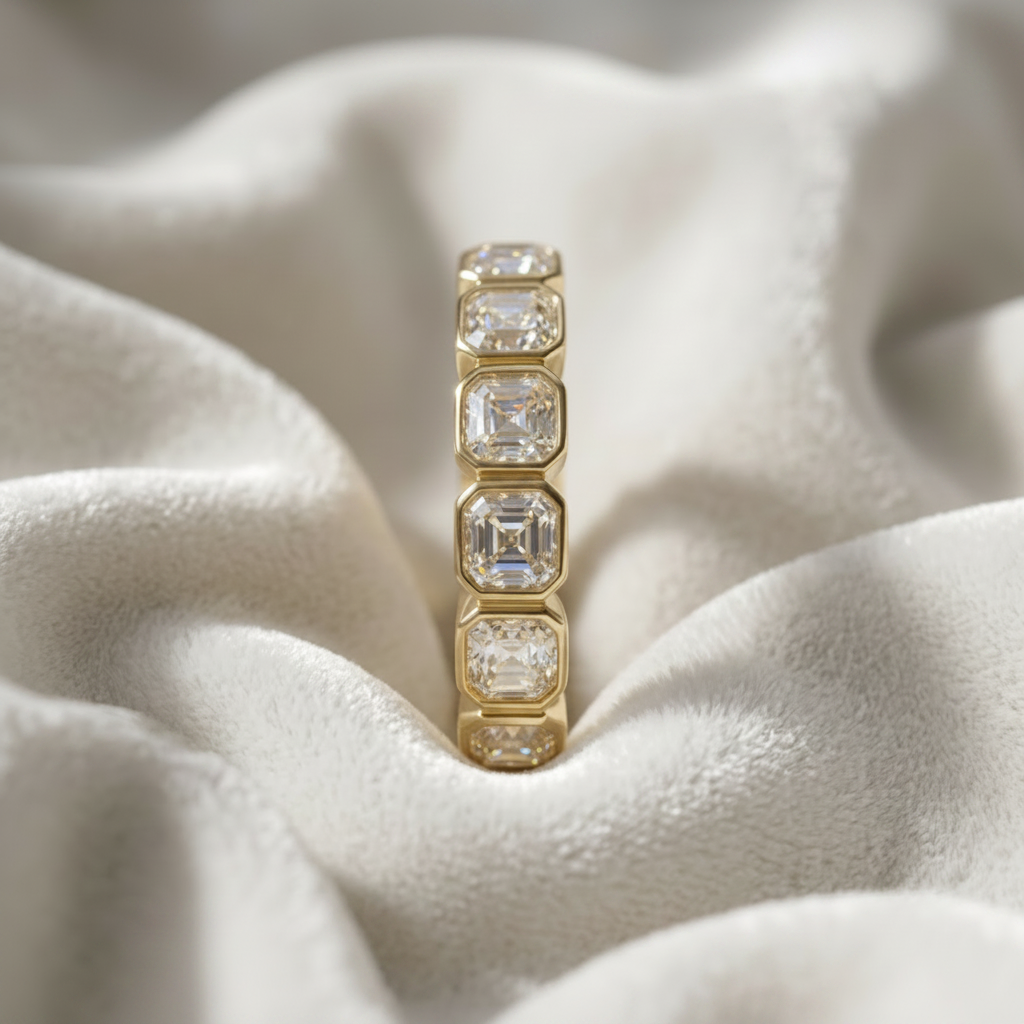 14K gold bezel set Asscher cut lab grown diamond wedding band on wavy white velvet, studio lighting