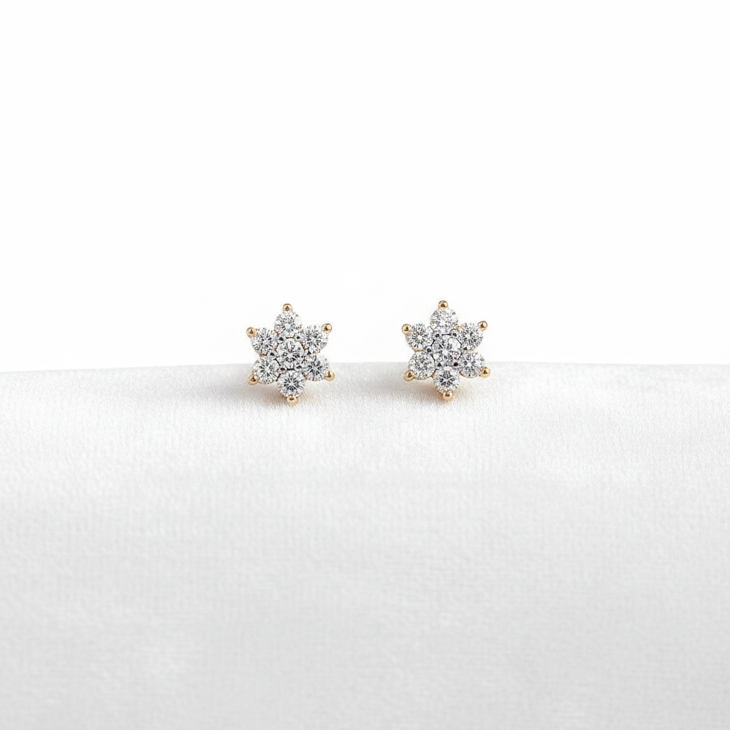 14K gold diamond flower stud earrings on white velvet, studio lighting macro shot