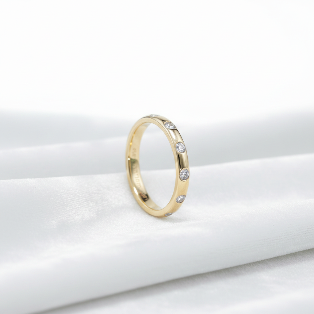 14K gold flush set lab grown diamond wedding band on wavy white velvet, studio lighting