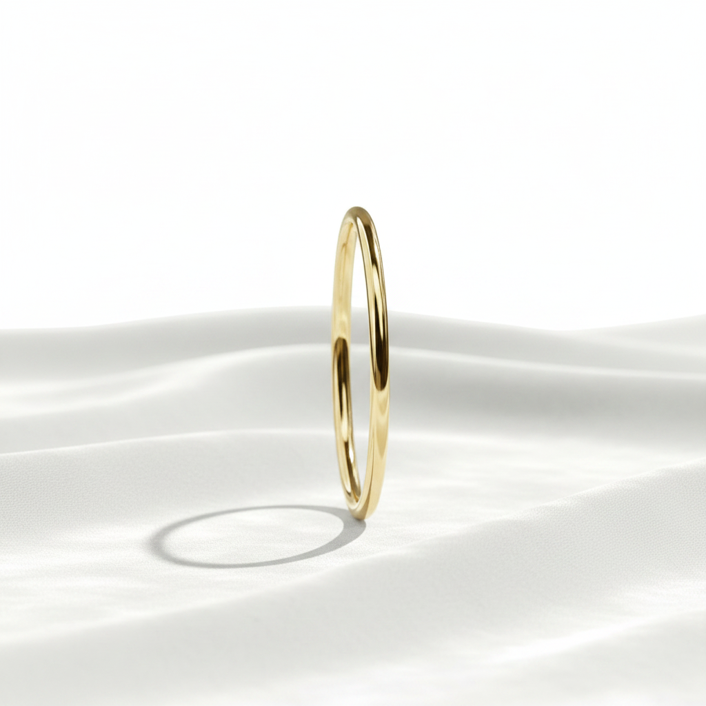 14K gold 1mm thin plain polished wedding band on wavy white velvet, studio lighting